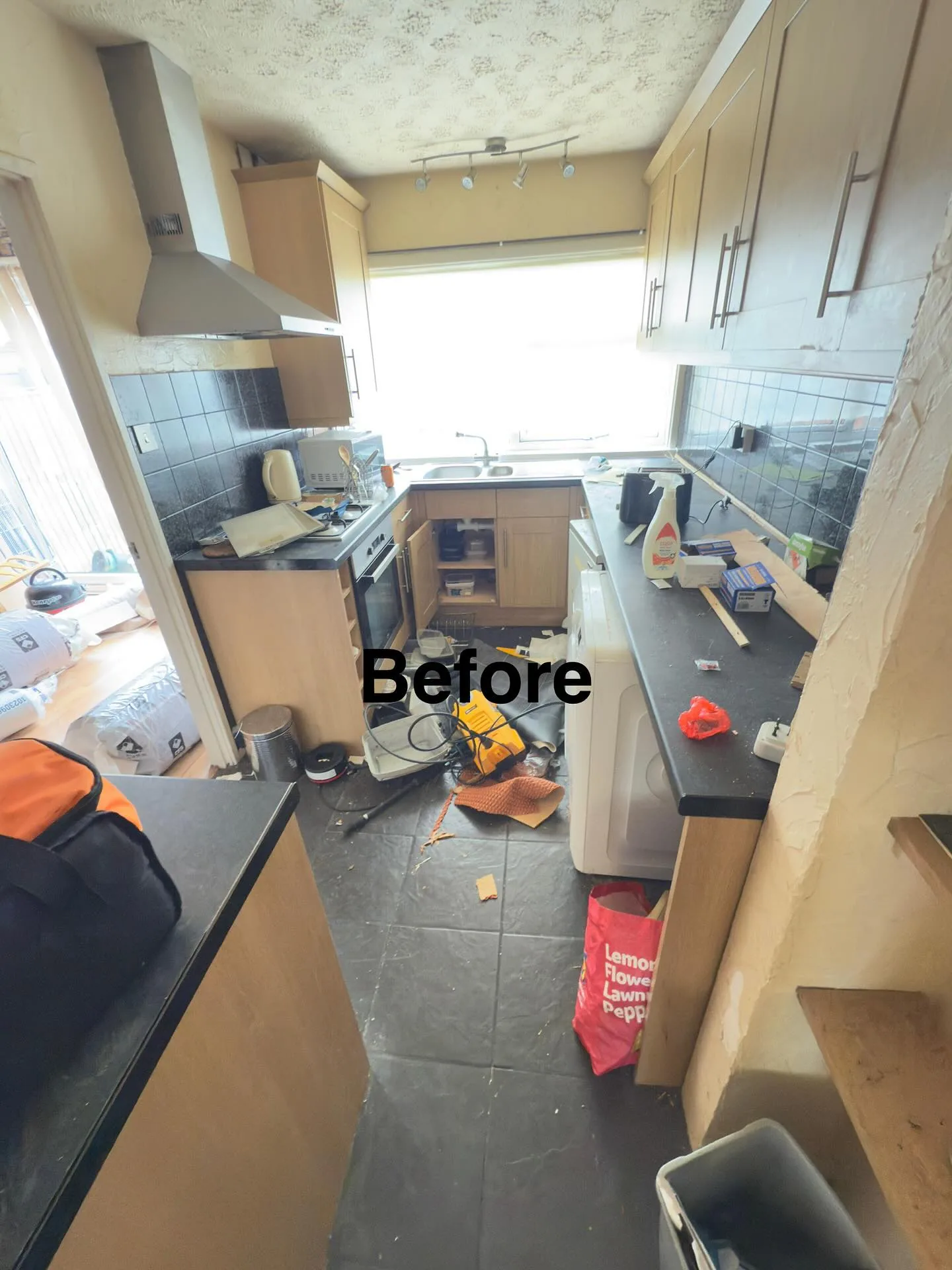 Kitchen cluttered with tools and packaging before a clearance clean