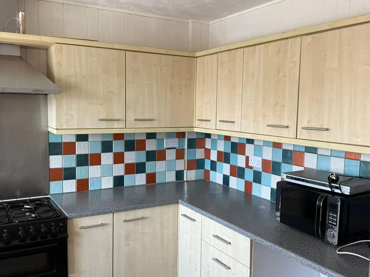Kitchen with colourful mosaic tile splashback, clean and bright
