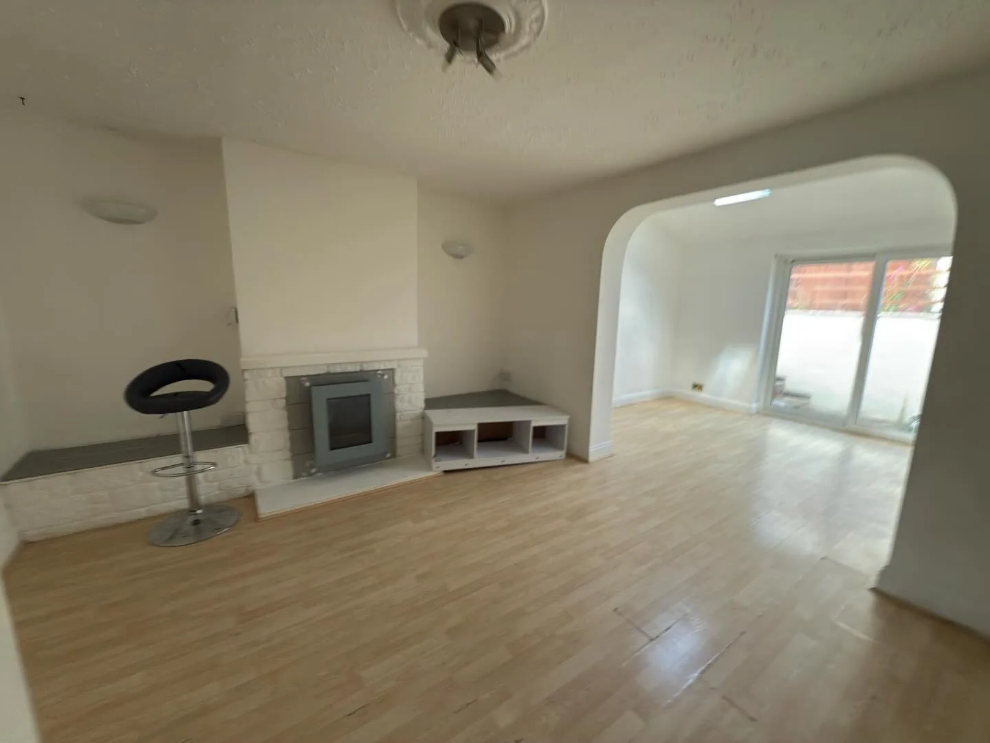 Empty living room with archway and clean laminate flooring