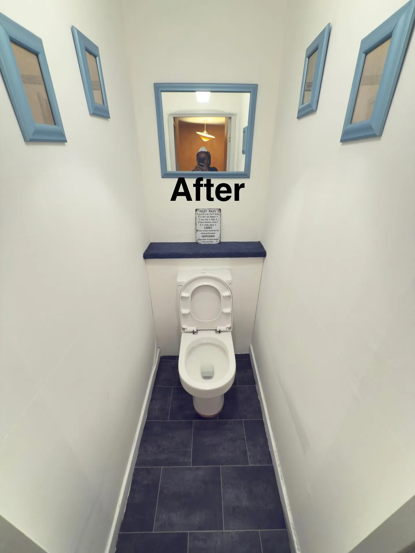 Neat bathroom toilet area with framed mirror after cleaning